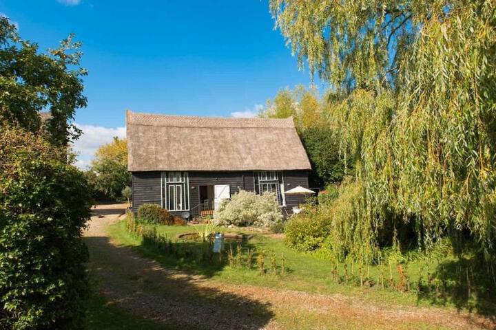 Exterior of Deepwell Granary is a lovely thatched barn with attached meadow woodland